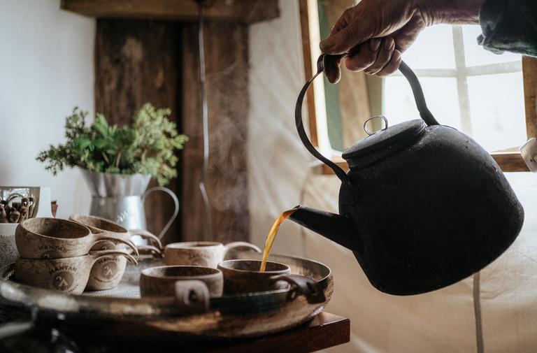 Kahvia kaadetaan kuppiin nokipannusta.
